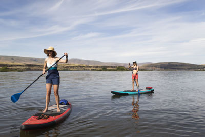 Two female friends enjoy their sups on the columbia river in oregon.