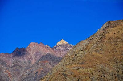 Scenic view of mountains against clear blue sky