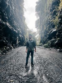 Full length portrait of man standing on road