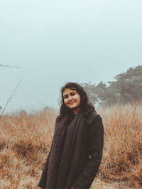 Young woman standing on field against clear sky