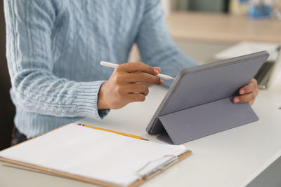 Midsection of man using mobile phone
