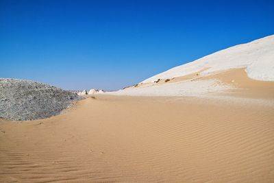 Scenic view of desert against clear blue sky