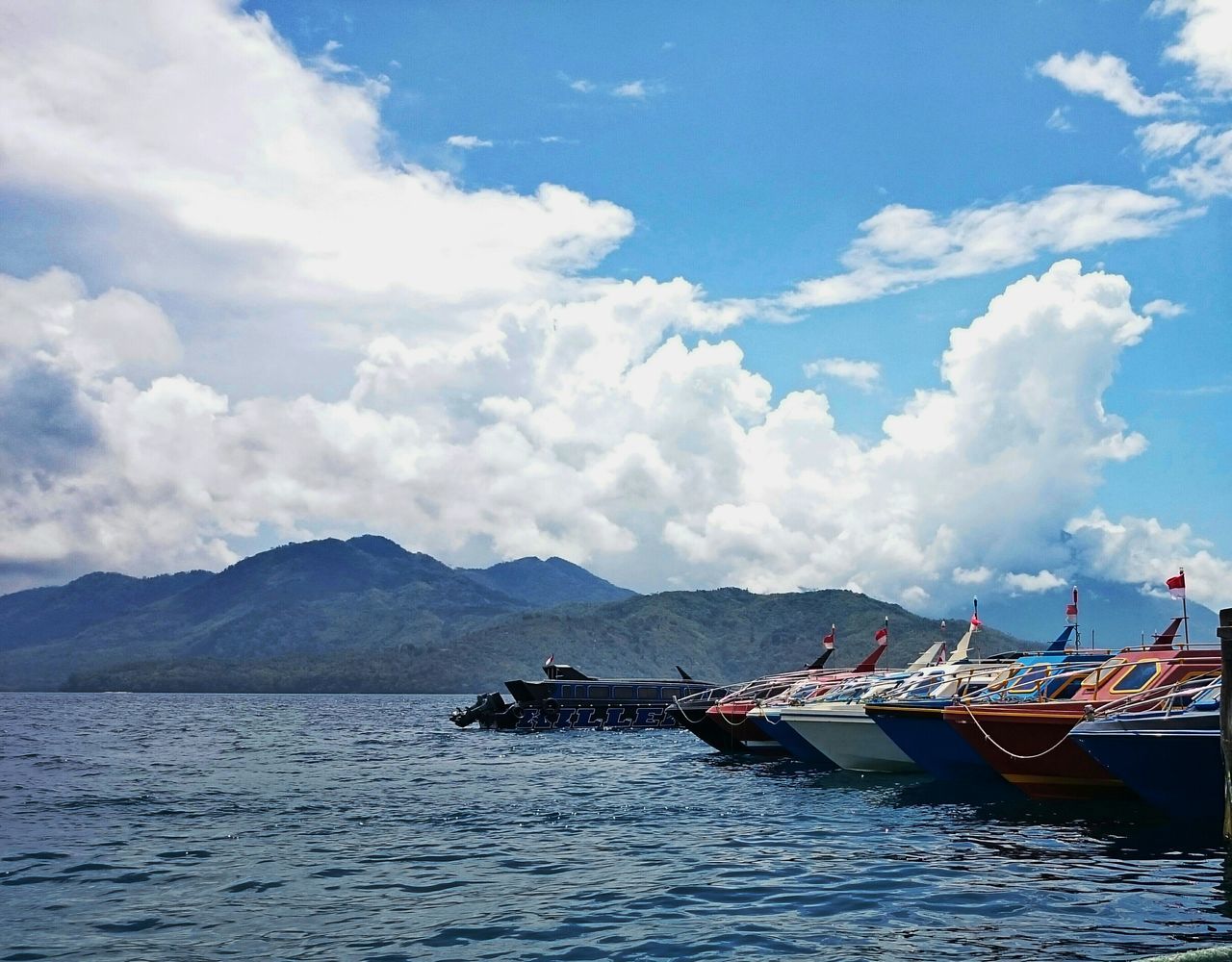 nautical vessel, transportation, boat, mode of transport, water, sky, moored, mountain, sea, waterfront, cloud - sky, tranquility, tranquil scene, cloud, scenics, sailing, nature, travel, mountain range, beauty in nature