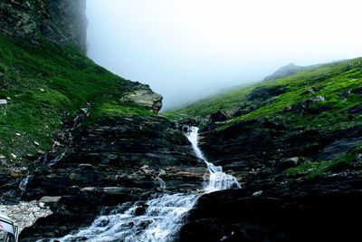 Scenic view of waterfall against sky