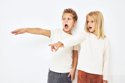 Happy friends standing against white background