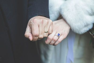 Midsection of bride and groom showing wedding rings