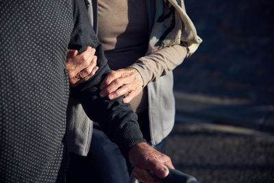 Midsection of couple holding hands