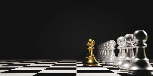 Low angle view of chess pieces against black background