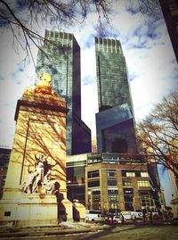 Low angle view of buildings against cloudy sky