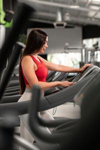 A pretty caucasian woman using a treadmill at the gym