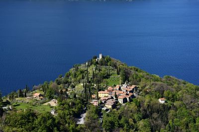 Aerial view of green mountains by blue sea on sunny day