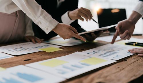Midsection of business colleagues working on table