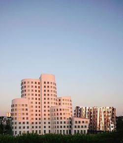 Low angle view of buildings against clear blue sky