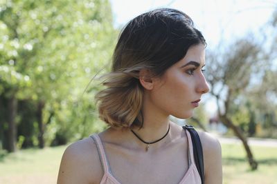 Close-up of thoughtful young woman standing at park