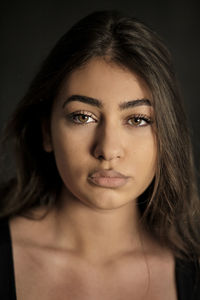 Portrait of beautiful woman against black background