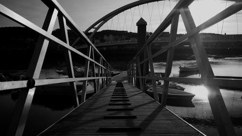 Footbridge over river against sky