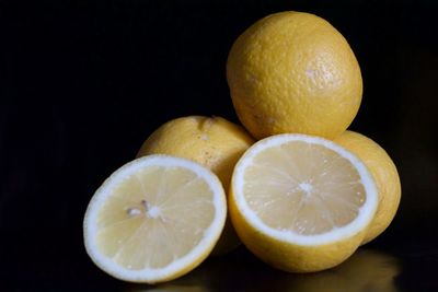 Close-up of fruits on table against black background