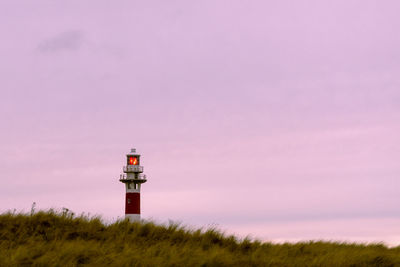 Lighthouse by sea against sky