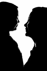 Close-up of silhouette woman over black background