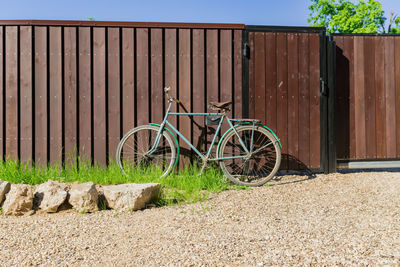 Old bicycle parked at a wooden fence, countrycide landscape