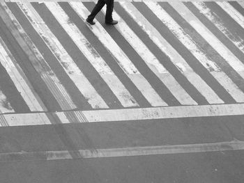 Low section of man crossing road