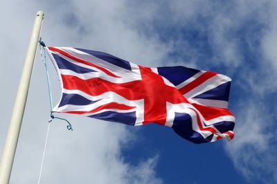 Low angle view of british flag waving against sky