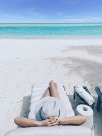 High angle view of woman relaxing at beach against sky