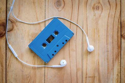 High angle view of audio cassette and headphones on table