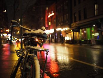 Close-up of bicycle on wet street at night