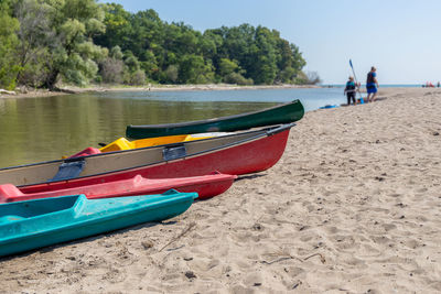 Boat moored on beach against sky