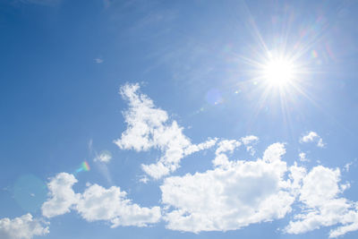 Low angle view of sunlight streaming through clouds