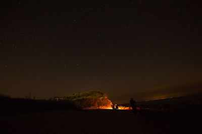 Scenic view of silhouette field against sky at night