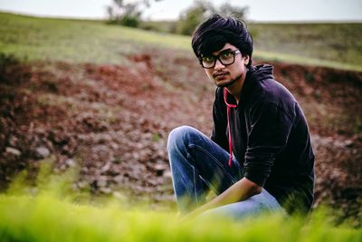 Young man sitting on field