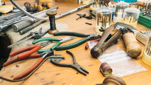 Set of various professional instruments and tools placed on shabby wooden table in jeweler workshop