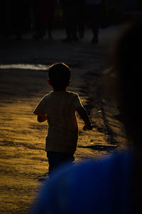 Rear view of boy standing in water