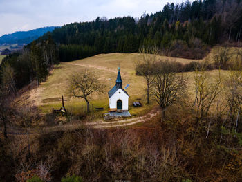 Church amidst trees and buildings against sky