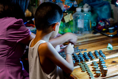 Woman and boy stacking coins on table