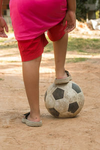 Low section of boy playing with soccer ball