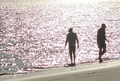 Rear view of people walking on road