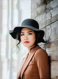 Portrait of beautiful woman standing against wall