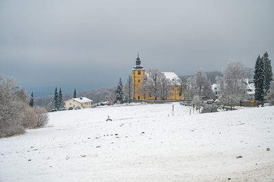 Built structures on snow covered landscape against clear sky