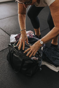 Senior woman packing equipment after workout in gym