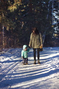Full length of mother and daughter on snow during winter