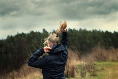 Full length of woman standing on field against sky
