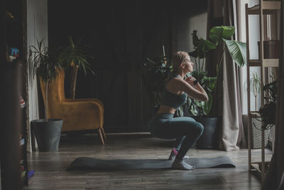 Woman exercising with resistance band in living room