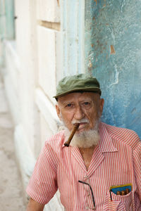 Portrait of man wearing hat against wall