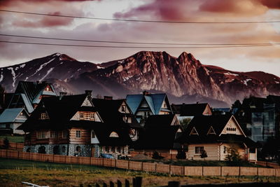 Houses and buildings against sky at dusk