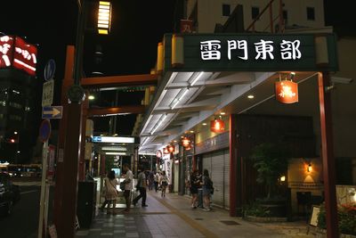 People in illuminated city at night