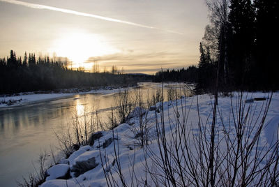 Scenic view of frozen lake against sky during sunset