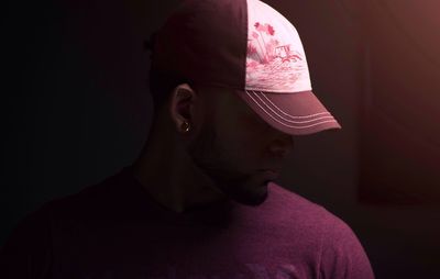 Close-up of man wearing cap in dark